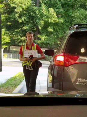 A person holding a sign next to a car

Description automatically generated with medium confidence